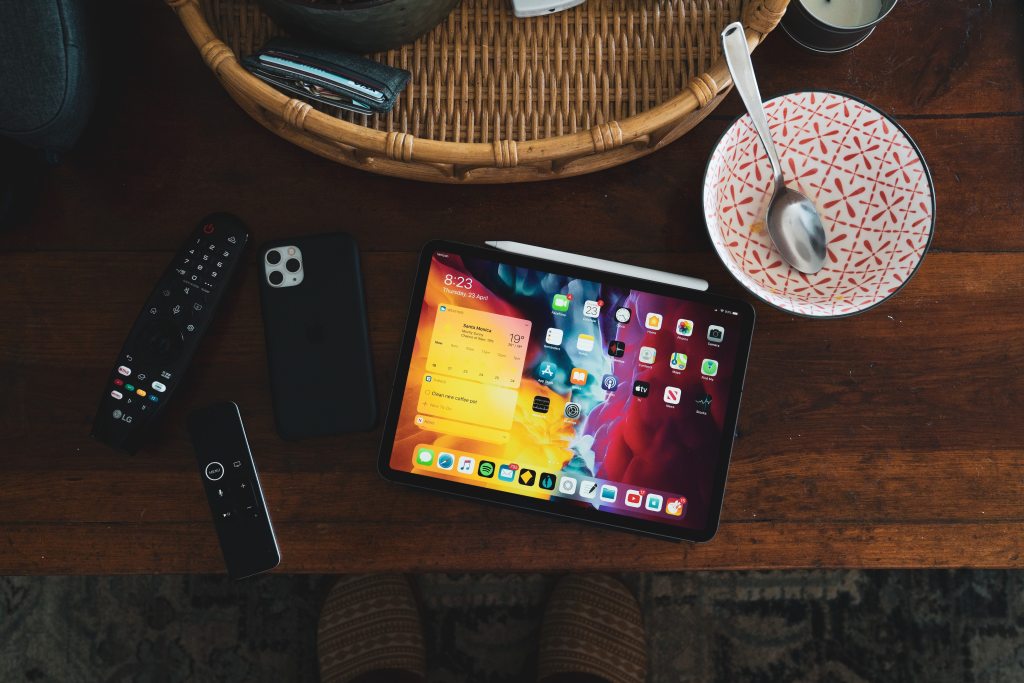 table with devices and empty breakfast bowl