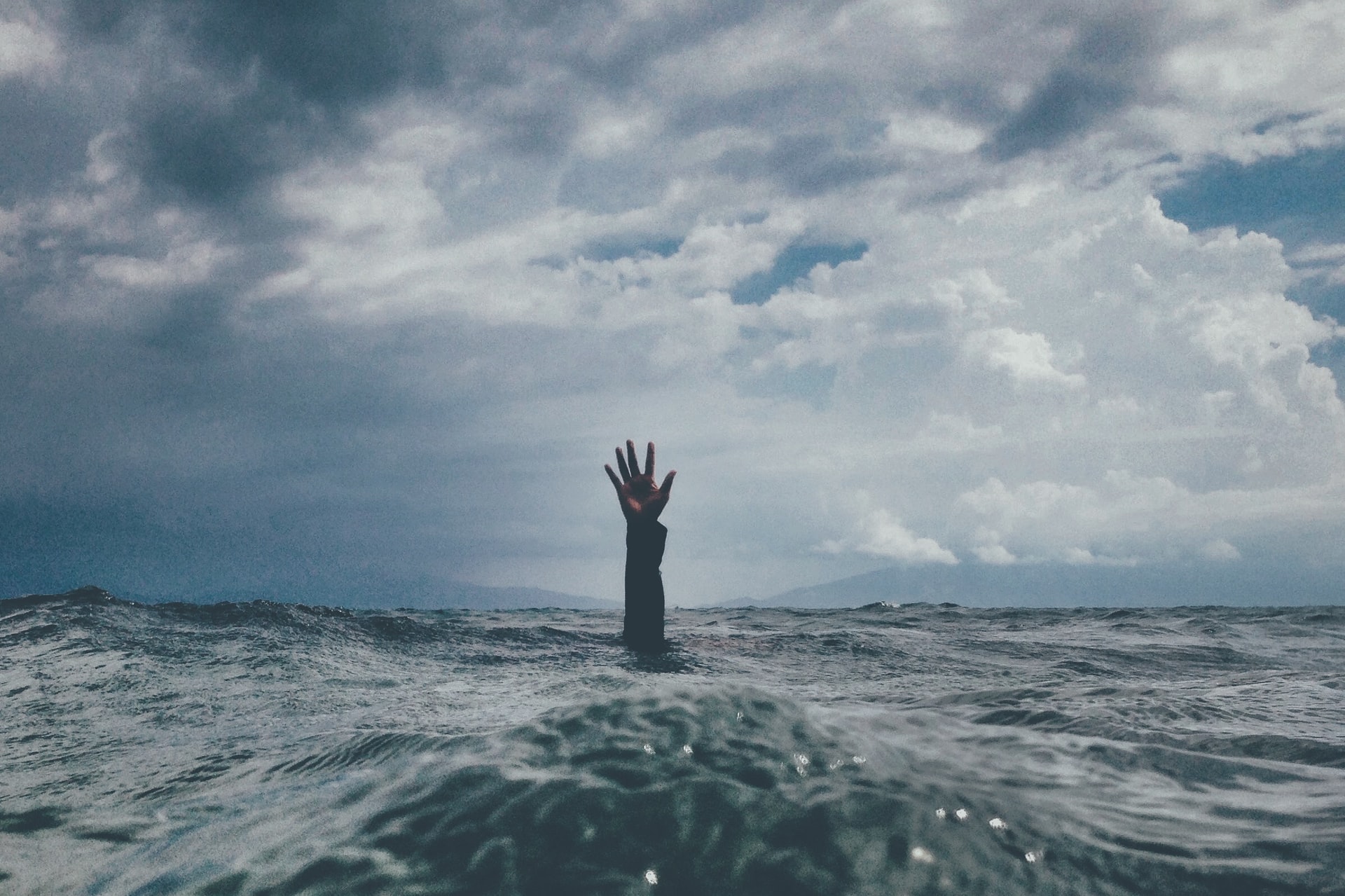 Hand reaching up out of the ocean