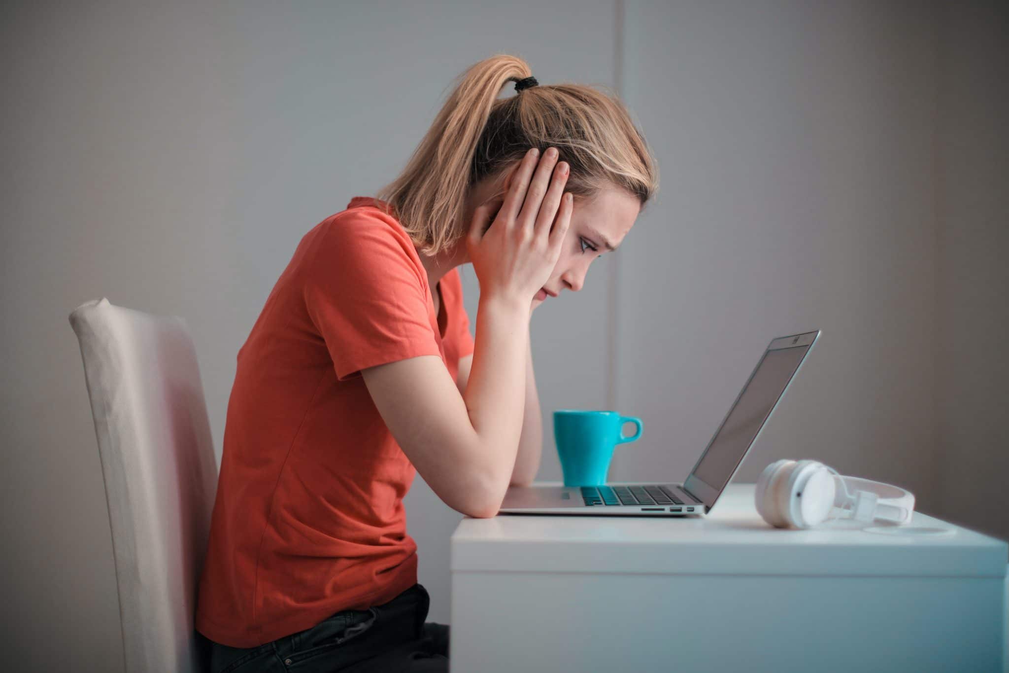 Woman with analysis paralysis trying to make decision with computer