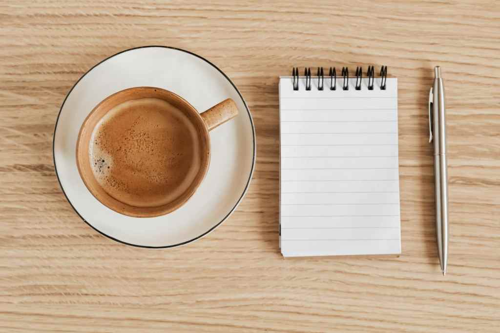 coffee cup blank notepad and pen on desk