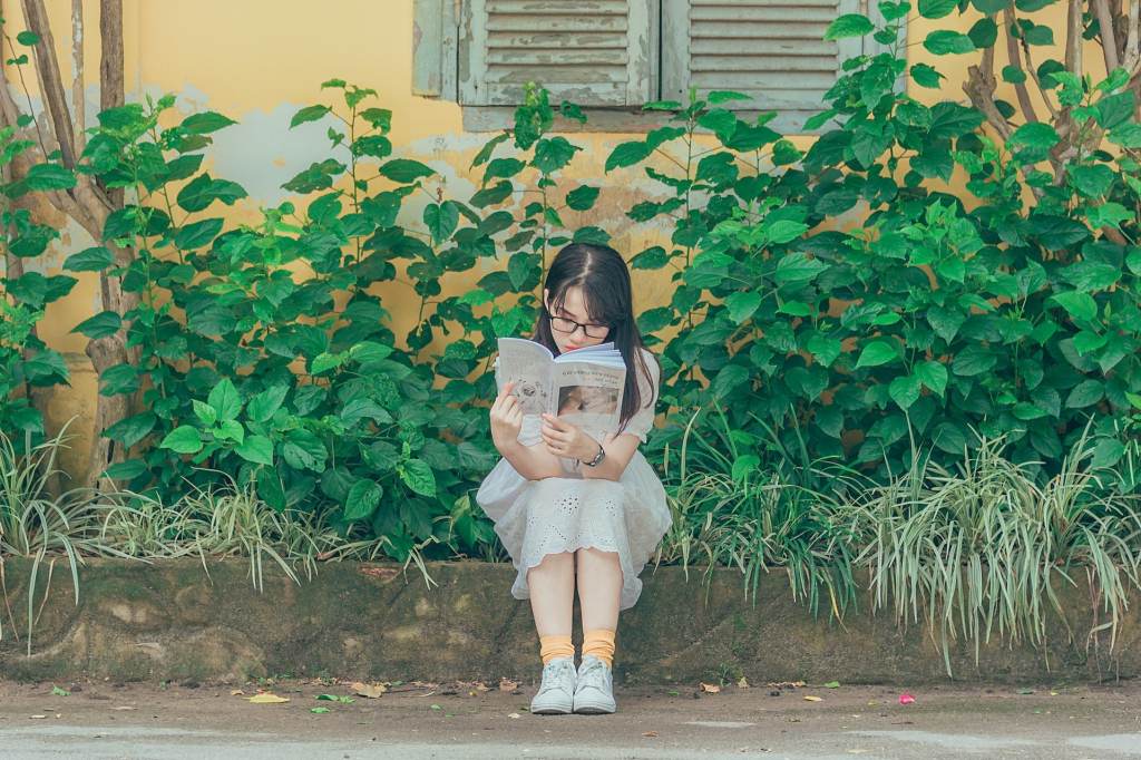 Girl reading book outdoors