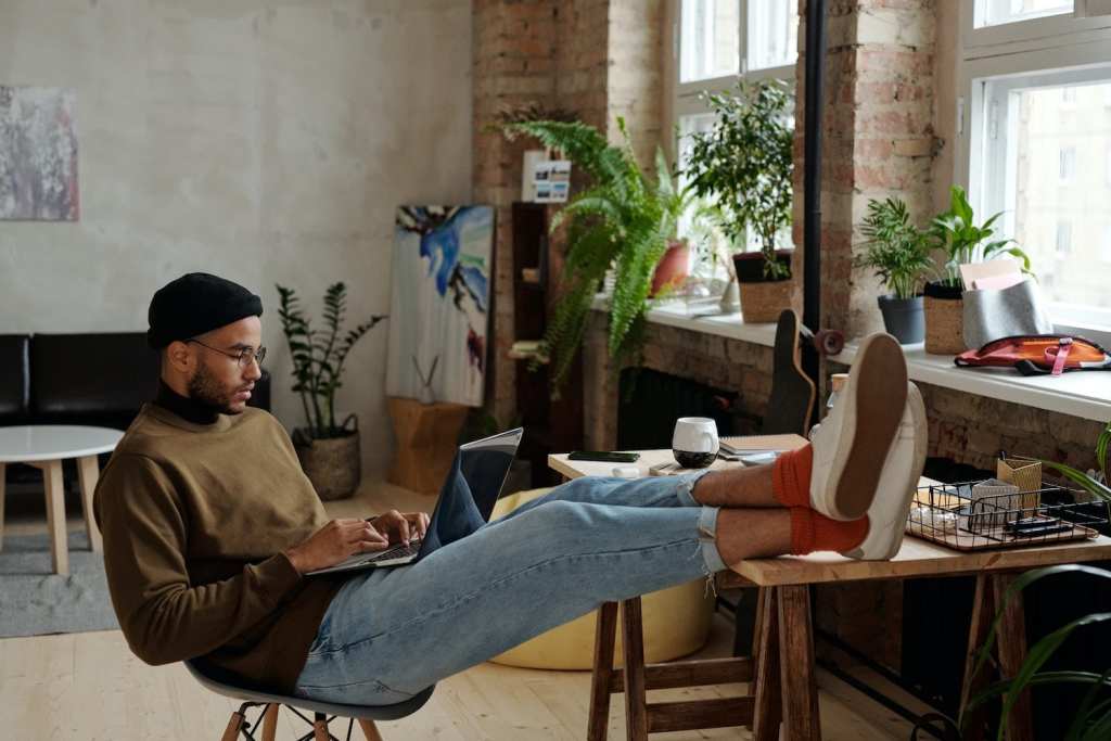 Young man working at home relaxed in apartment creative