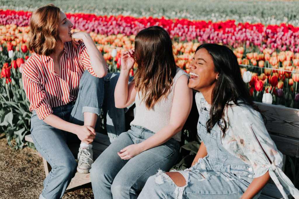 Relationships are better than phones - 3 young women sitting on a bench and laughing