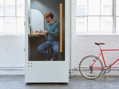 focus guide - Man working undistracted in a telephone box with a desk