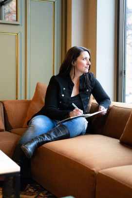 Heather Thorkelson sitting on couch in workspace